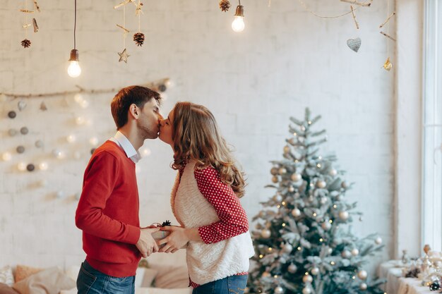 Jovem casal dá presentes de natal para o outro