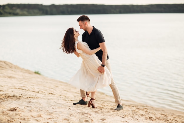 Jovem casal dançando na praia