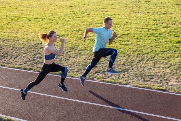 Jovem casal de atleta em forma, menino e menina correndo