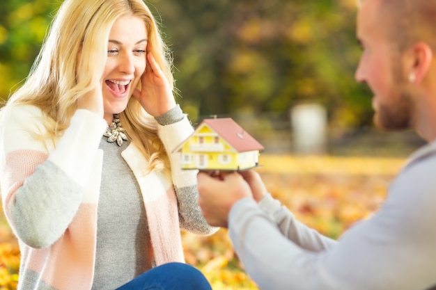 Jovem casal de casamento marido surpreende esposa cônjuge com nova casa de família hipoteca feliz casa.