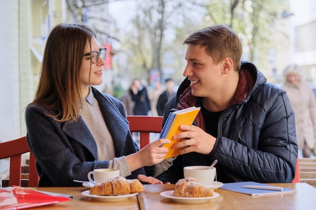 Jovem casal de estudantes estuda no café ao ar livre