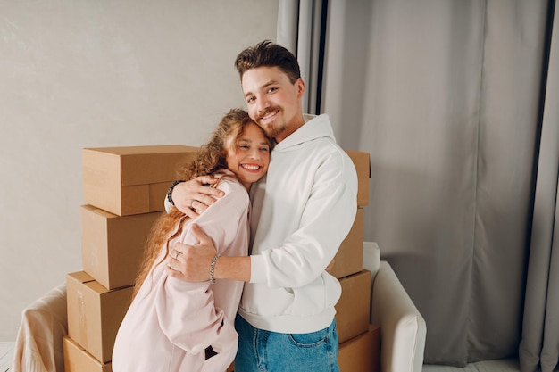 Foto jovem casal de família feliz homem e mulher abraçando e se mudando com caixas de papelão para o novo apartamento da casa de propriedade