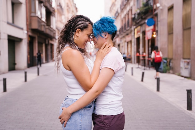 Foto jovem casal de lésbicas beijando e mostrando carinho na rua.