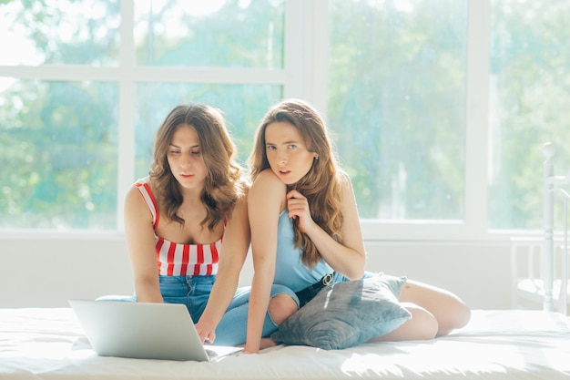 jovem casal de lésbicas com laptop na cama