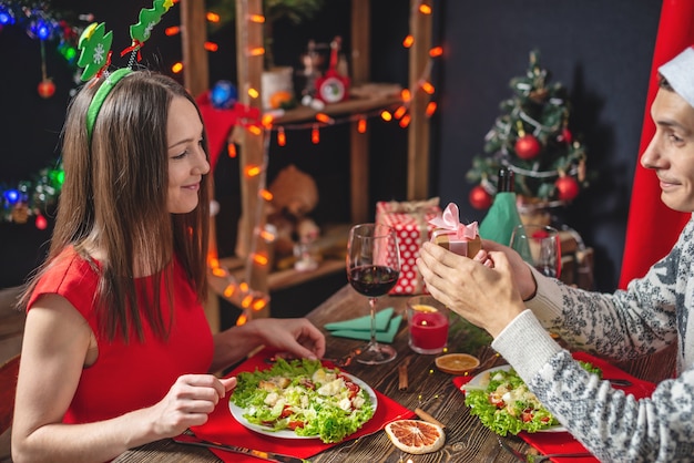 Jovem casal de namorados lindos passando um jantar festivo de Natal