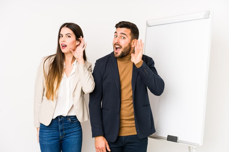 Foto jovem casal de negócios caucasiano isolado tentando ouvir uma fofoca.
