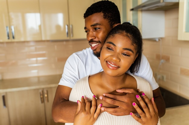 Foto jovem casal de raça mista feliz passando seu tempo em casa na cozinha