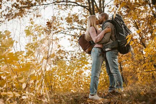 Jovem casal de turistas beijando na floresta ao ar livre