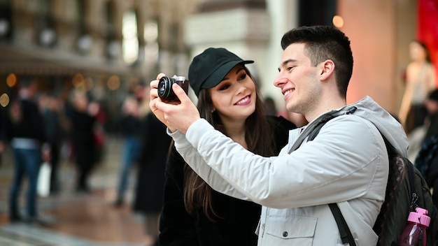 Jovem casal de turistas tirando fotos na cidade