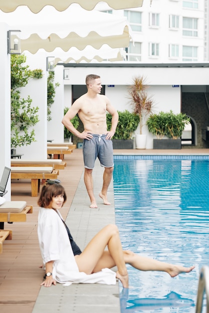 Jovem casal descansando na piscina