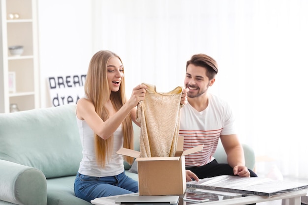 Jovem casal desempacotando encomendas em casa