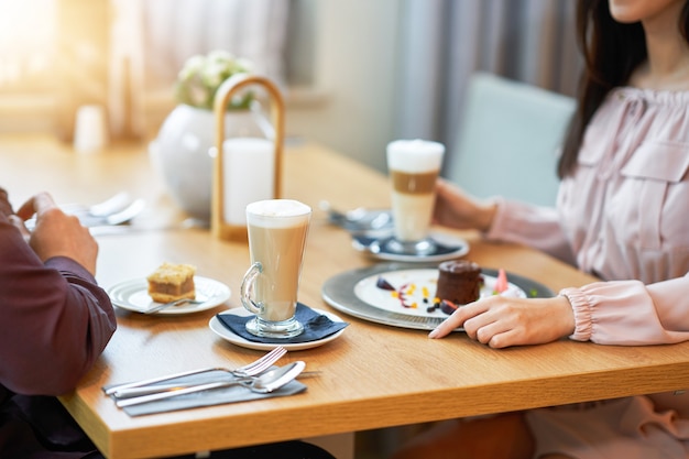 Jovem Casal Desfrutando De Café E Bolo No Café