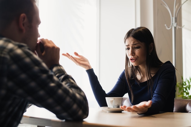 Jovem casal discutindo em um café