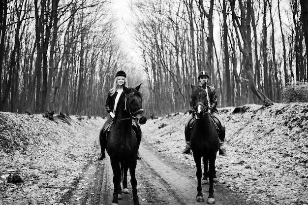 Jovem casal elegante, andar a cavalo na floresta de outono