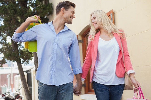 Jovem casal elegante com bolsas de compras