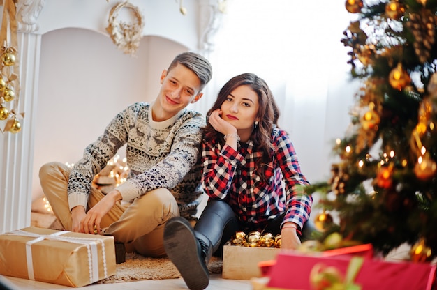 Jovem casal elegante com presentes de Natal e decoração de ano novo