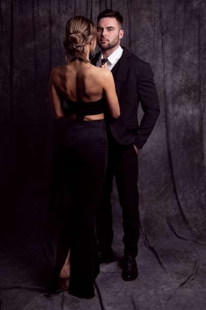 Jovem casal elegante em roupas pretas posando