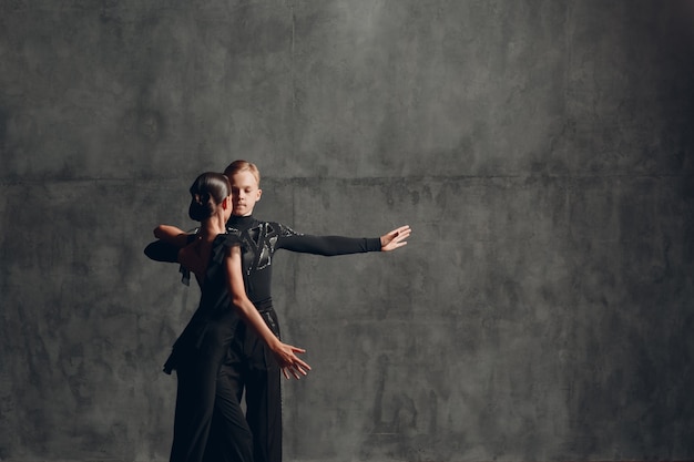 Jovem casal em dança de salão negra dança paso doble.