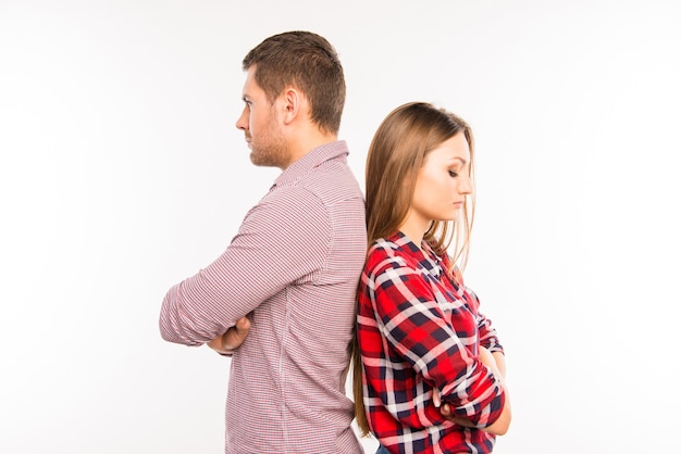 Jovem casal em pé de costas um para o outro, se ignorando