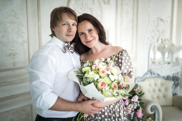 Jovem casal encantador e linda mulher com um buquê de rosas