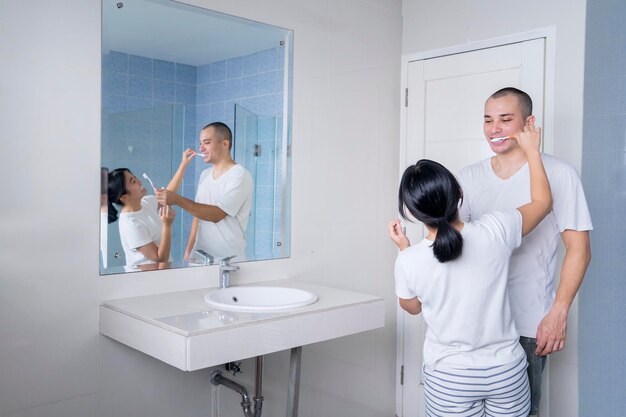 Jovem casal escovando os dentes no banheiro