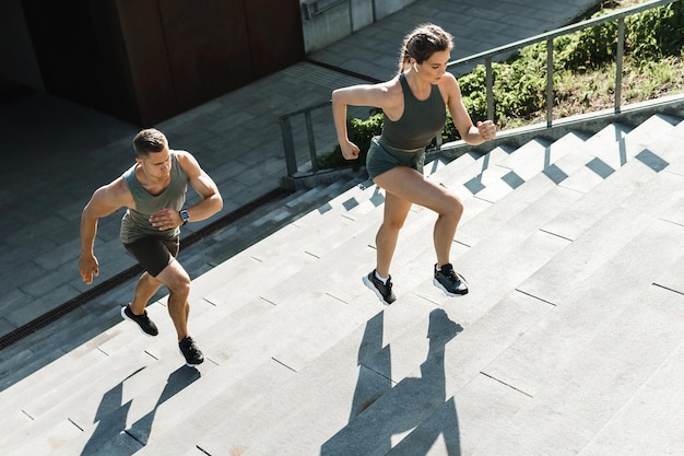 Jovem casal esportivo correndo escada de ginástica ao ar livre