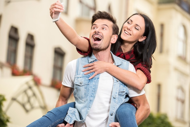 Jovem casal está andando na cidade e tirar uma foto.