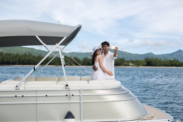 Jovem casal está viajando em um iate no oceano Índico Na proa do barco uma família amorosa