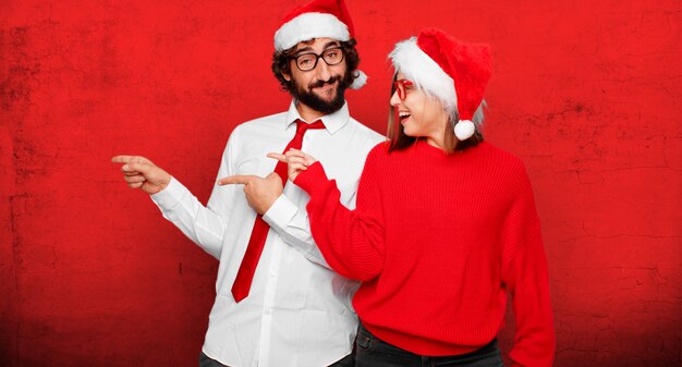 Jovem casal expressando o conceito de natal. casal e plano de fundo em diferentes camadas