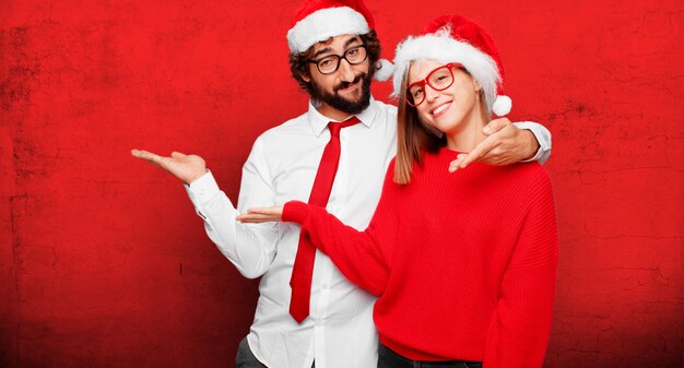 Jovem casal expressando o conceito de Natal. casal e plano de fundo em diferentes camadas