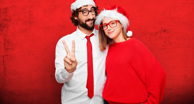 Jovem casal expressando o conceito de Natal. casal e plano de fundo em diferentes camadas