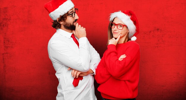 Jovem casal expressando o conceito de Natal. casal e plano de fundo em diferentes camadas