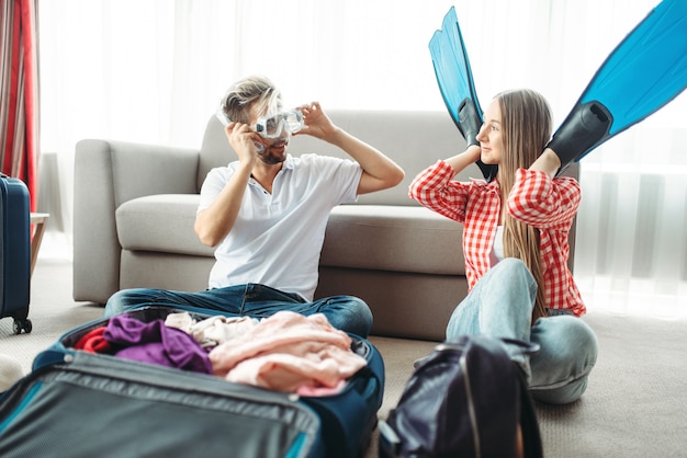 Jovem casal fazendo as malas para as férias