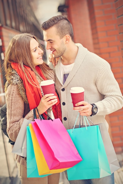 Foto jovem casal fazendo compras na cidade