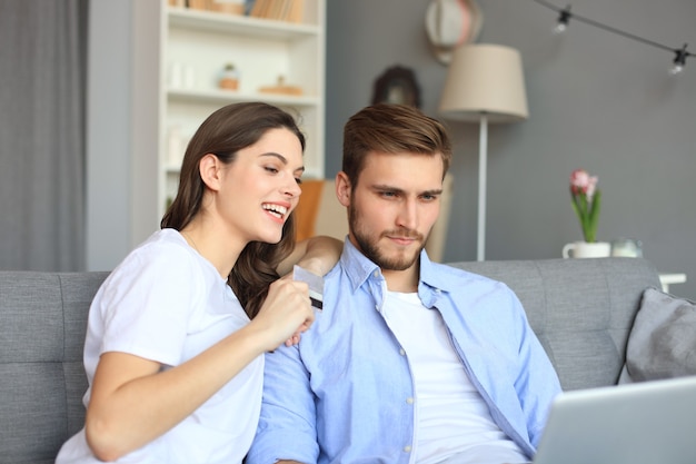 Jovem casal fazendo compras online em casa.