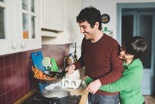 Jovem casal fazendo o jantar juntos