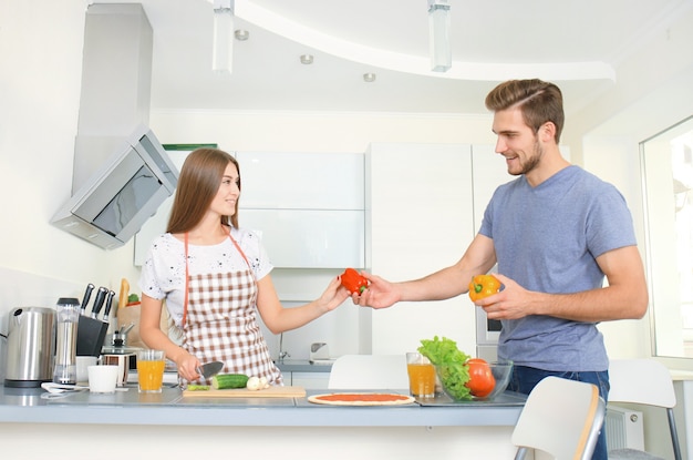 Jovem casal fazendo pizza na cozinha juntos