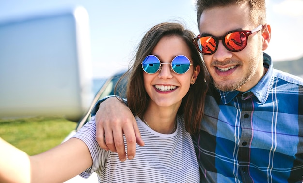 Jovem casal fazendo uma selfie no carro