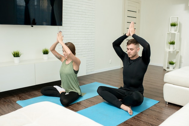 Jovem casal fazendo yoga