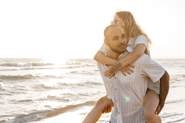 Jovem casal feliz à beira-mar curtindo o mar