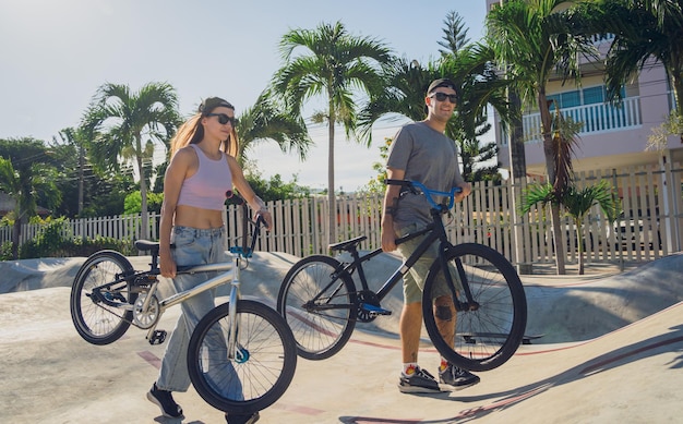 Jovem casal feliz a desfrutar de um passeio de BMX no skatepark