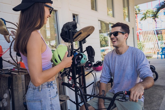 Foto jovem casal feliz a desfrutar de um passeio de bmx no skatepark