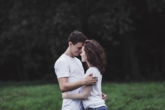 Jovem casal feliz andando ao ar livre e se abraçando