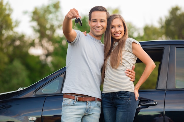 Jovem casal feliz andando de carro sorrindo - conceito de comprar carro
