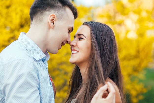 Jovem casal feliz apaixonado ao ar livre Homem e mulher em uma caminhada em um parque florescente de primavera