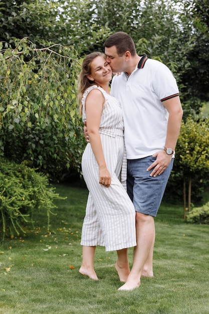 Jovem casal feliz beijando e abraçando ao ar livre num dia de verão.