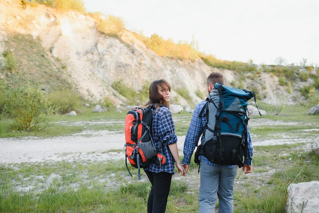 Jovem casal feliz caminhando na montanha