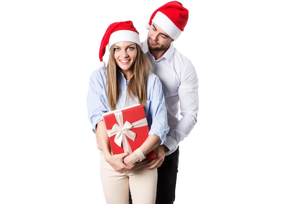 Jovem casal feliz com chapéu de Papai Noel e caixas de presente