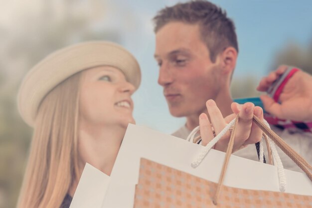 Jovem casal feliz com sacolas de compras na cidade.