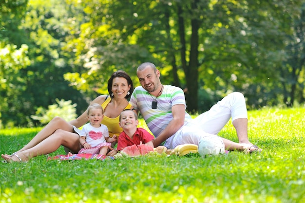 Jovem casal feliz com seus filhos se divertindo em um belo parque ao ar livre na natureza